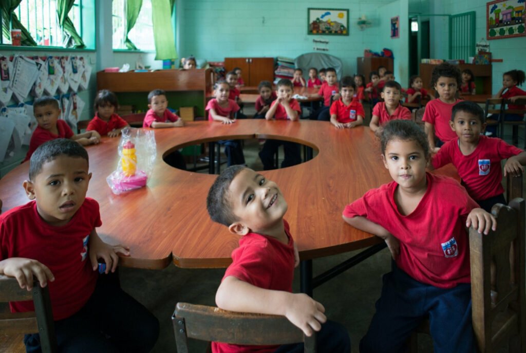 children sitting at round table at school